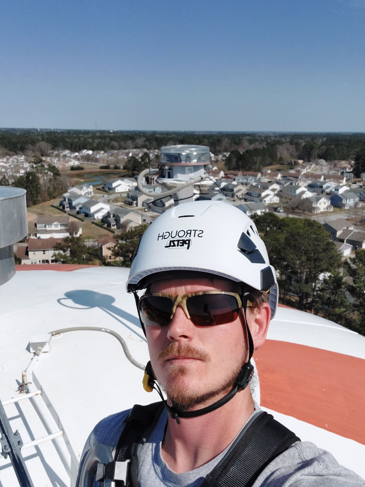 Shane Thomas Strough climbing water tower with Petzl helmet